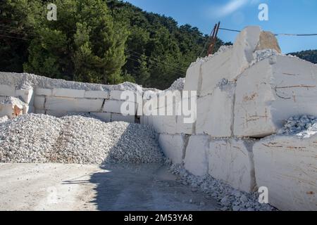 Weißer Marmorstein in Blöcken, soeben mit schweren Maschinen aus dem Bergwerk ausgegraben, bereit für die Weiterverarbeitung bis zum Endprodukt. Jeder Steinblock hat 5T. Stockfoto