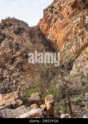 Schroffe Felsformationen flankieren einen steilen Pass auf Abschnitt 3 des Larapinta Trail über Standley Chasm, West MacDonnell (Tjoritja) National Park. Stockfoto