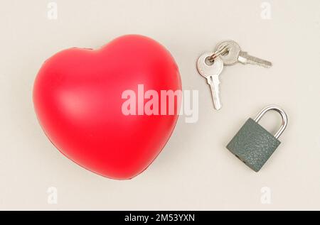 Menschen- und Symbolkonzept. Auf der grauen Oberfläche befinden sich Herz, Schloss und Tasten. Stockfoto