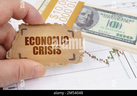 Geschäfts- und Finanzkonzept. Vor dem Hintergrund von Dollars und einer Zitattabelle hält ein Mann ein Schild in den Händen mit der Inschrift "ECON" Stockfoto