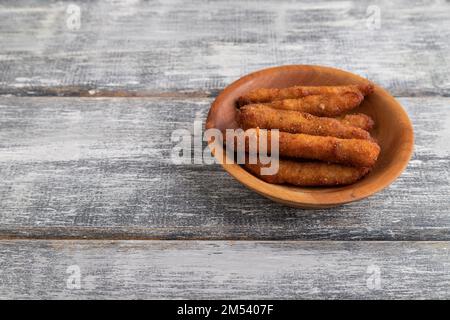 Chicken Nuggets auf einem Holzteller auf grauem Holzhintergrund. Seitenansicht, Nahaufnahme, Kopierbereich. Stockfoto