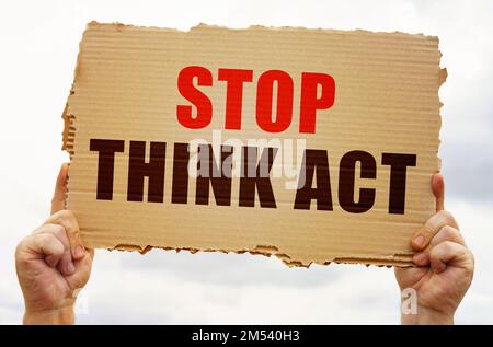 Geschäftskonzept. In den Händen eines Mannes ist ein Pappschild mit der Aufschrift "Stop Think Act" Stockfoto