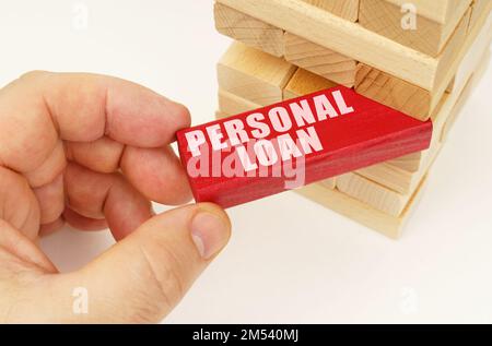 Geschäfts- und Technologiekonzept. Aus dem Turm mit Holzplanken nehmen sie eine rote Tafel mit der Inschrift - persönlicher Kredit Stockfoto