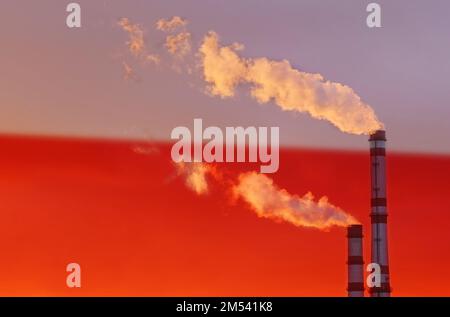 Ökologisches Konzept. Vor dem Hintergrund der polnischen Flagge strömt Rauch aus den Schornsteinen eines Industrieunternehmens und verunreinigt die Luft. Stockfoto