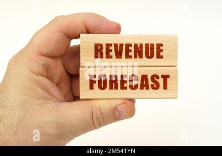 Geschäftskonzept. Auf weißem Hintergrund eine Hand, die Holzblöcke mit der Aufschrift „Revenue Forecast“ hält Stockfoto