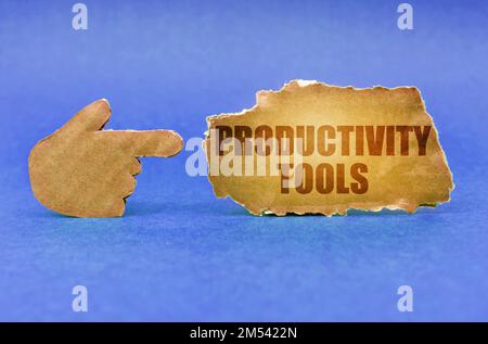 Geschäftskonzept. Auf einer blauen Oberfläche zeigt eine Papphand auf ein Schild mit der Aufschrift „Produktivitäts-Tools“ Stockfoto