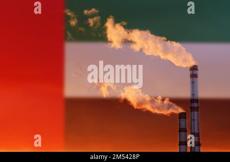 Ökologisches Konzept. Vor dem Hintergrund der Flagge der Vereinigten Arabischen Emirate strömt Rauch aus den Rohren eines Industrieunternehmens und verschmutzt die Luft. Stockfoto