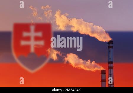 Ökologisches Konzept. Vor dem Hintergrund der slowakischen Flagge strömt Rauch aus den Schornsteinen eines Industrieunternehmens und verschmutzt die Luft. Stockfoto