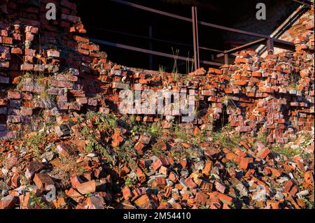 Blick auf die zerstörte rote Backsteinmauer, Nahaufnahme. Stockfoto