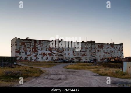 Ein verlassenes mehrstöckiges Gebäude steht in der Mitte des Feldes. Stockfoto