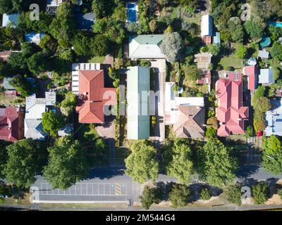 Wohnstraße mit Vorstadthäusern von oben, grünen Bäumen, Gärten und Parkplätzen am Straßenrand. Castlemaine, Victoria, Australien. Stockfoto