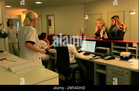 Diese GP-Gruppenpraxis mit vier GPS- und acht Arzthelfern versorgt eine große Anzahl von Patienten in einer mittelgroßen Stadt. Empfang Stockfoto