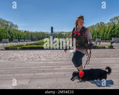 Deutschland, Berlin, 09. 05. 2020, Siegesfeier (über Hitlers Faschismus), Sowjetdenkmal Berlin-Treptow, Soldatin mit Hund, Blumen Stockfoto