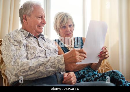 In den letzten Jahren immer finanziell klug bleiben. Ein älteres Paar, das zu Hause seine Papiere zusammen durchsucht. Stockfoto