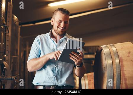 Wenn Sie keine Lösung haben, suchen Sie online nach einer. Ein gutaussehender junger Sommelier, der sein digitales Tablet bei der Arbeit benutzt. Stockfoto