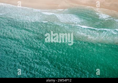 Luftaufnahme vom Hubschrauber mit Surfer, der am Tai Wan Beach, Sai Kung East Country Park, Hongkong auf die Welle wartet Stockfoto