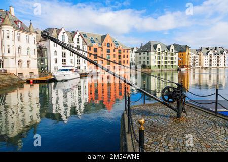 Blick auf das Stadtbild in Alesund in Norwegen am Kanal mit einem alten Kran Stockfoto