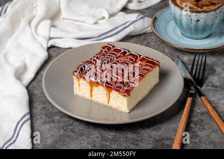 Kuchenscheibe aus Trilece auf dunklem Hintergrund. Milch und Karamellkuchen. Backwaren. Mexikanische Süßigkeiten. Schließen Stockfoto