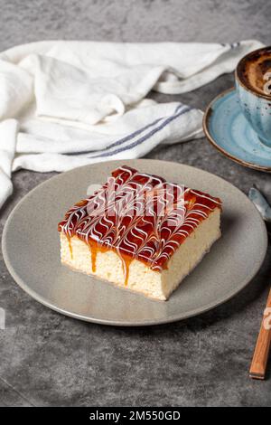 Kuchenscheibe aus Trilece auf dunklem Hintergrund. Milch und Karamellkuchen. Backwaren. Mexikanische Süßigkeiten. Schließen Stockfoto