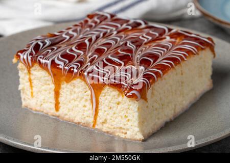 Kuchenscheibe aus Trilece auf dunklem Hintergrund. Milch und Karamellkuchen. Backwaren. Mexikanische Süßigkeiten. Schließen Stockfoto