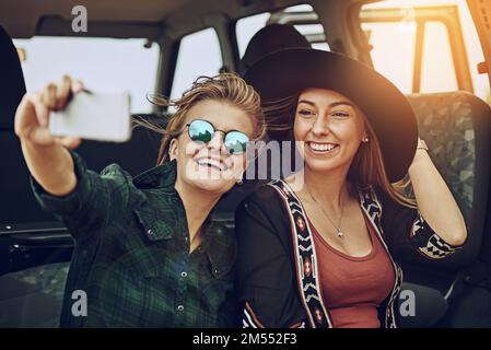 Zusammen die schönsten Erinnerungen schaffen. Zwei junge Freunde machen ein Selfie, während sie zusammen unterwegs sind. Stockfoto