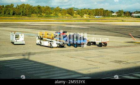 Kerkyra, Griechenland - 09 29 2022: Blick auf den Flughafen Korfu auf leere und beladene Wagen mit Gepäck bei sonnigem Wetter. Stockfoto