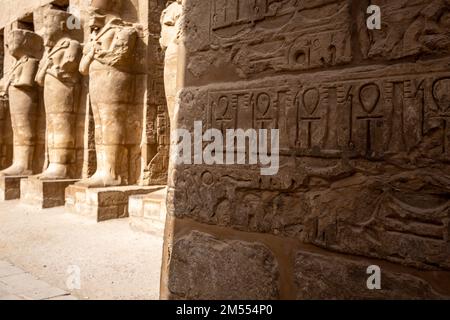 Hieroglypisch bemalte Schnitzereien an der Wand des alten ägyptischen Tempels in Luxor. Ägypten. Stockfoto