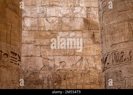 Hieroglypisch bemalte Schnitzereien an der Wand des alten ägyptischen Tempels in Luxor. Ägypten. Stockfoto