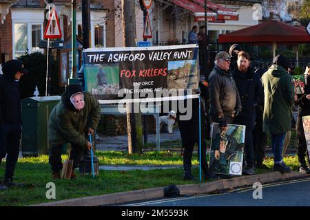 Tenterden, Kent, Großbritannien. 26. Dezember 2022. Das jährliche Treffen am zweiten Weihnachtsfeiertag der Ashford Valley Tickham Hunt findet an einem hellen und sonnigen, aber kalten Morgen in der Stadt Tenterden, Kent, statt. Pferde und Hunde versammeln sich um 11am Uhr im Pub „The Vine Inn“, bevor es die Hauptstraße hinunter zu einem vollgepackten Publikum geht. Die Demonstranten kommen früh und bereiten sich in der Nähe der Jagd vor. Foto: Paul Lawrenson/Alamy Live News Stockfoto