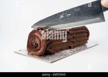 Schneiden Sie ein Stück schokoladenweihnachtslog isoliert auf weißem Hintergrund mit Kopierbereich Stockfoto