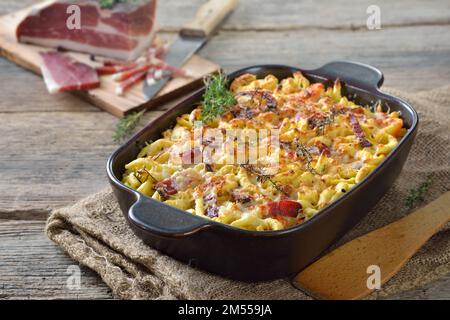 Hausgemachter Spaetzle-Auflauf mit Parmesan, Gemüse und Südtiroler Speck, serviert mit einer köstlichen Käsekruste frisch aus dem Ofen Stockfoto