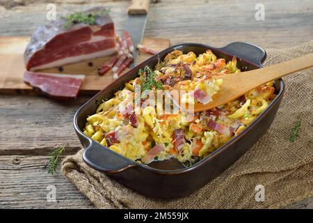 Hausgemachter Spaetzle-Auflauf mit Parmesan, Gemüse und Südtiroler Speck, serviert mit einer köstlichen Käsekruste frisch aus dem Ofen Stockfoto