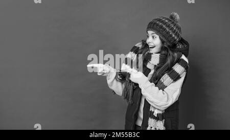 ausdruck positiver Emotionen. Wintermode. Zeigefinger auf Kopierraum. Stockfoto