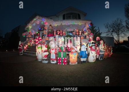 Ein Fischaugenblick auf ein weihnachtlich dekoriertes Haus mit über 100 Statuen auf dem Rasen und der Veranda. In Queens, New York City. Stockfoto