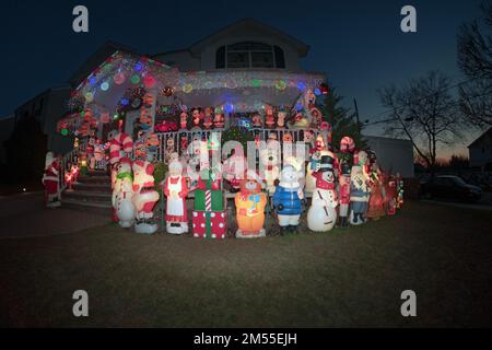 Ein Fischaugenblick auf ein weihnachtlich dekoriertes Haus mit über 100 Statuen auf dem Rasen und der Veranda. In Queens, New York City. Stockfoto