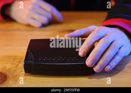adsl-Modem auf dem Tisch vor der Person im Hintergrund Stockfoto