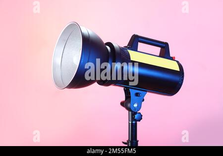 studio-Blitz auf einem Stativ und pinkfarbenem Hintergrund Stockfoto