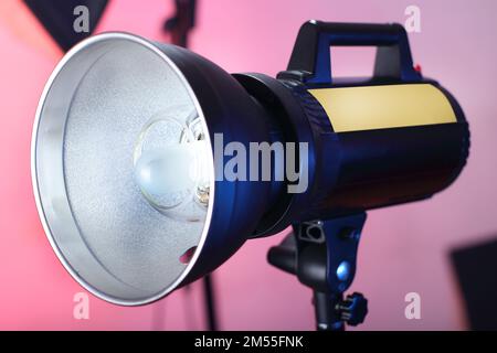 studio-Blitz auf einem Stativ und pinkfarbenem Hintergrund Stockfoto
