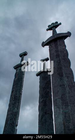 Ein vertikales Bild des Monuments „Swords in Rock“ unter dem düsteren Himmel in Stavanger, Norwegen Stockfoto