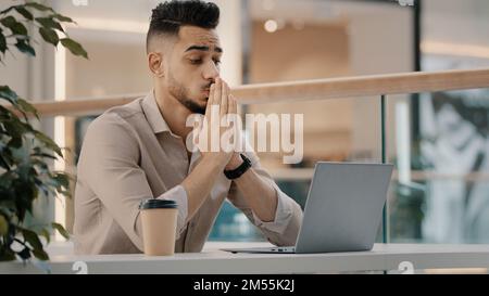 Indisch-hispanischer Geschäftsmann männlicher Arbeiter Mann im Café mit Laptop betet Gott um Hilfe, Glück Glück Glück Hoffnung bete Wunsch gewollt Win Wishing Stockfoto