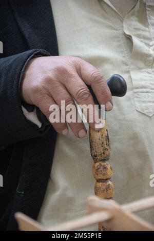 Eine vertikale Nahaufnahme eines alten Mannes, der seinen Stock hält Stockfoto