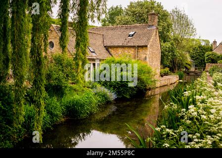 Cotswold Steinhaus am Fluss Windrush in der Nähe des Dorfes Naunton, England. Stockfoto