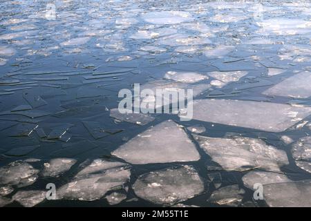 Viele zerbrochene kleine Eisschollen treiben auf dem blauen Fluss aus der Vogelperspektive Stockfoto