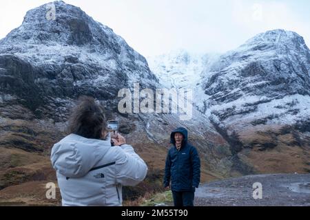 Glen Coe, Schottland, Großbritannien. 26. Dezember 2022 Touristen halten heute an, um den Blick auf die schneebedeckten Berge in Glen Coe zu bewundern. Am zweiten Weihnachtsfeiertag fiel in den schottischen Highlands schwerer Schnee auf höherem Boden. In Glen Coe Iain Masterton/Alamy Live News Stockfoto