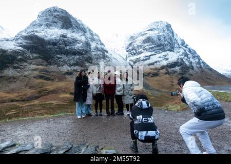 Glen Coe, Schottland, Großbritannien. 26. Dezember 2022 Touristen halten heute an, um den Blick auf die schneebedeckten Berge in Glen Coe zu bewundern. Am zweiten Weihnachtsfeiertag fiel in den schottischen Highlands schwerer Schnee auf höherem Boden. In Glen Coe Iain Masterton/Alamy Live News Stockfoto