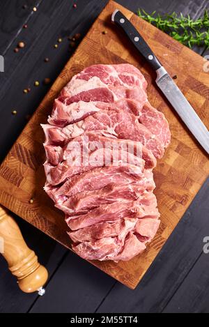 Rohes Fleisch. Rohes Rindfleischsteak auf ein Schneidebrett mit Rosmarin und Gewürzen. Stockfoto