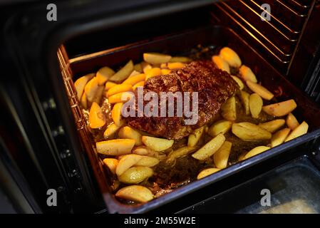 Das Fleisch wird im Ofen gebacken. Hausgemachtes Fleisch mit Kartoffeln Stockfoto