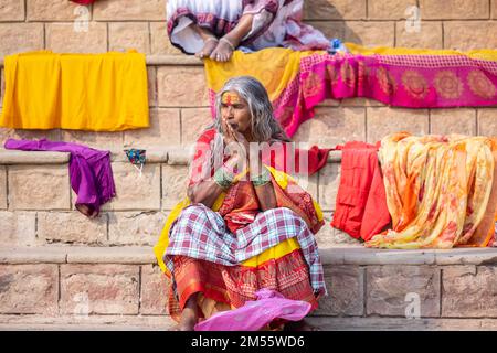 Varanasi, Indien: Porträt einer alten südindischen Frau, die in der Nähe von kedar Ghat in einer traditionellen Saree mit kahlem Kopf sitzt. Selektiver Fokus auf Augen und Gesicht. Stockfoto
