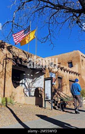 Das 1917 gegründete New Mexico Museum of Art auf der West Palace Avenue in Santa Fe, New Mexico, mit der Flagge der USA und New Mexicos am 11. November 2022. Stockfoto