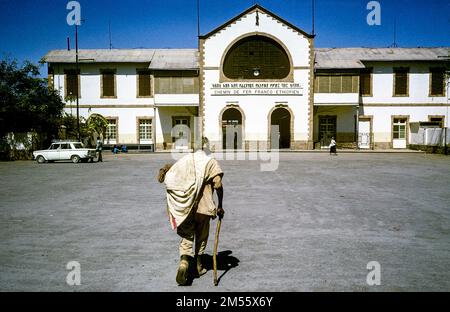 Äthiopien, 1970er, Dre Dawa, Rückansicht eines Mannes, der mit einem Stock läuft, Bahnhof Chemin de Fer Franco-Äthiopien, Dre Dawa Region, Ostafrika, Stockfoto